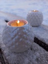 white candlesticks with candles on a wooden bench in winter