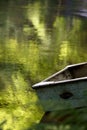 an empty white canoe sitting on the side of the water