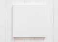 White canvas frame mock up template square size on white wood wall for arts painting and photo hanging interior decoration Royalty Free Stock Photo