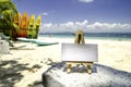 White canvas frame and wooden tripod on the tropical beach background at sunny day.