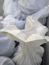 Detail of White debris raffia sack. White Canvas Membrane Plastic Bags With Construction Trash. Pile of plastic rubble sacks in