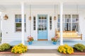 white cape cod with blue door, porch swing, and flower boxes Royalty Free Stock Photo