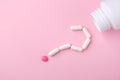 White capsules falling from the white bottle in the form of a question. Royalty Free Stock Photo