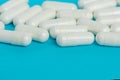 White capsules of medicine lie on a blue background Royalty Free Stock Photo
