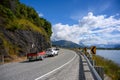 A white car with a boat Running on a curved road up the hill in the summer in wanaka lake Royalty Free Stock Photo