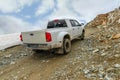 White car with a body rides up a stony road to the top of a rock Royalty Free Stock Photo