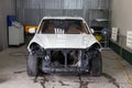 The white car in the body of the suv is preparing for painting the body without headlights and bumper in a workshop for repair