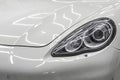 White car. Close-up of hood, headlight and headlight washer Royalty Free Stock Photo