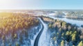 White car drives empty road running along the beautiful blue lake in the cold Finnish winter Royalty Free Stock Photo