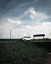 A white car drives fast by an area sign showing the name of the nearby lake SvaneholmssjÃÂ¶n in southern Sweden Scania