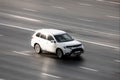 White car Mitsubishi Outlander ES fast drive on asphalt road, aerial front side view