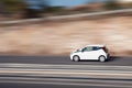 White car moving fast along the street on a motion blurred background. Car driving on freeway Royalty Free Stock Photo