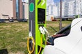 White car refueling at green automobile filling station. Modern fuel oil gasoline dispenser at petrol filling station