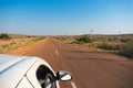 White car running through empty high road or national high way passing through the desert. Distant horizon, Hot summer at Thar, Royalty Free Stock Photo