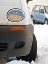 White car in snow with wheels turned to the left