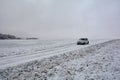 White car on snowy country lane Royalty Free Stock Photo