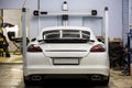 White car, sports executive class sedan on the stand convergence collapse in the service center. In tuning and repair center.