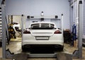 White car, sports executive class sedan on the stand convergence collapse in the service center. In tuning and repair center.