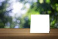 White card put on wooden desk or wooden floor on blurred green tree nature background.use for present or mock up your product Royalty Free Stock Photo