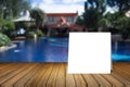 White card put on wooden desk or wooden floor on blurred swimming pool at resort background.use for present your product Royalty Free Stock Photo