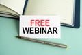 a white card with the text free webinar, open paper notebook on background Royalty Free Stock Photo