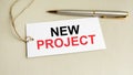 card with text New Project with metal pen on gray background Royalty Free Stock Photo