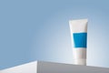 White care cosmetics tube with blue blank label mockup, face skin cream or mineral tooth paste container template on white table Royalty Free Stock Photo