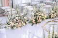 The white carpet for the wedding ceremony is decorated with flower compositions of roses, buttercup and bells with transparent cha