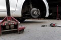 White cars change wheels using a lifting jack Royalty Free Stock Photo