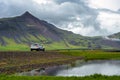 White cars parked on a dirt road The background is high mountains with green grass in the countryside in Iceland Royalty Free Stock Photo