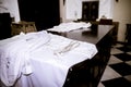 The white cassock of the priest lies on the table