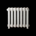 A white cast iron radiator on a black background Royalty Free Stock Photo