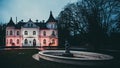 The White Castle - music school and fountain in Baldone, Latvia. The castle is illuminated in the dark in the colors of Latvia -