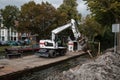 White Cat industrial digger floating on a raft barge on a river canal and excavating the bank Royalty Free Stock Photo