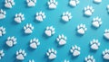 White cat paw prints arranged in a repeating pattern on a light blue background. The image shows multiple small animal footprints Royalty Free Stock Photo