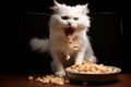 white cat at the table snapping at flying food. dark background Royalty Free Stock Photo