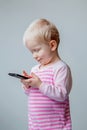 White Caucasian blond baby with blue eyes making a call, playing with mobile cell phone Royalty Free Stock Photo