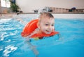 White Caucasian child in swimming pool. Preschool boy training to float with red circle ring in water Royalty Free Stock Photo