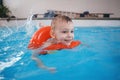 White Caucasian child in swimming pool. Preschool boy training to float with red circle ring in water Royalty Free Stock Photo