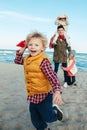 White Caucasian family, mother with three children kids playing paper planes, running on ocean sea beach on sunset outdoors Royalty Free Stock Photo