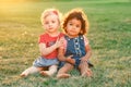 White Caucasian and latin hispanic babies hugging outside in park.