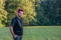 White caucasian man smiling at camera. Diverse alternative look with pink hair