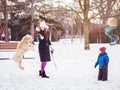 white Caucasian mother with toddler boy kid playing with large big pet dog outdoors on winter day