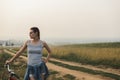 White caucasian young woman standing with bike on hill near road Royalty Free Stock Photo