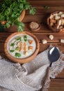 White cauliflower cream soup with ingredients in wooden bowls