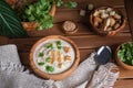 White cauliflower cream soup with ingredients in wooden bowls