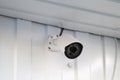 white CCTV surveillance camera mounted on wall of building