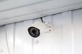white CCTV surveillance camera mounted on wall of building