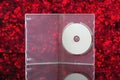 White CD in transparent box with red background Royalty Free Stock Photo