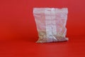 White cellophane cooking bag for preparing quick-digesting steamed buckwheat. Red background